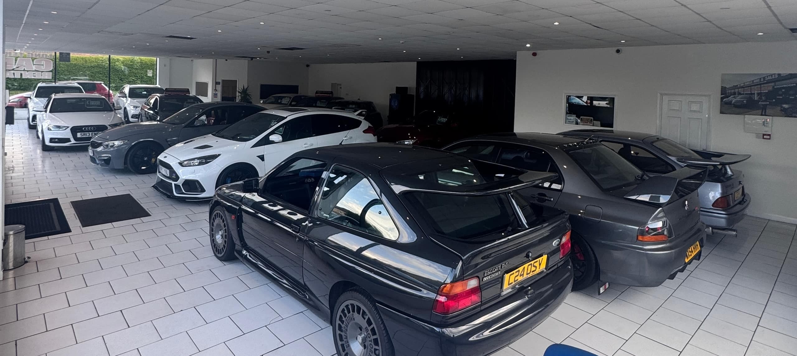 Inside the WMA Motors showroom — performance cars including an Escort RS Cosworth and Focus RS